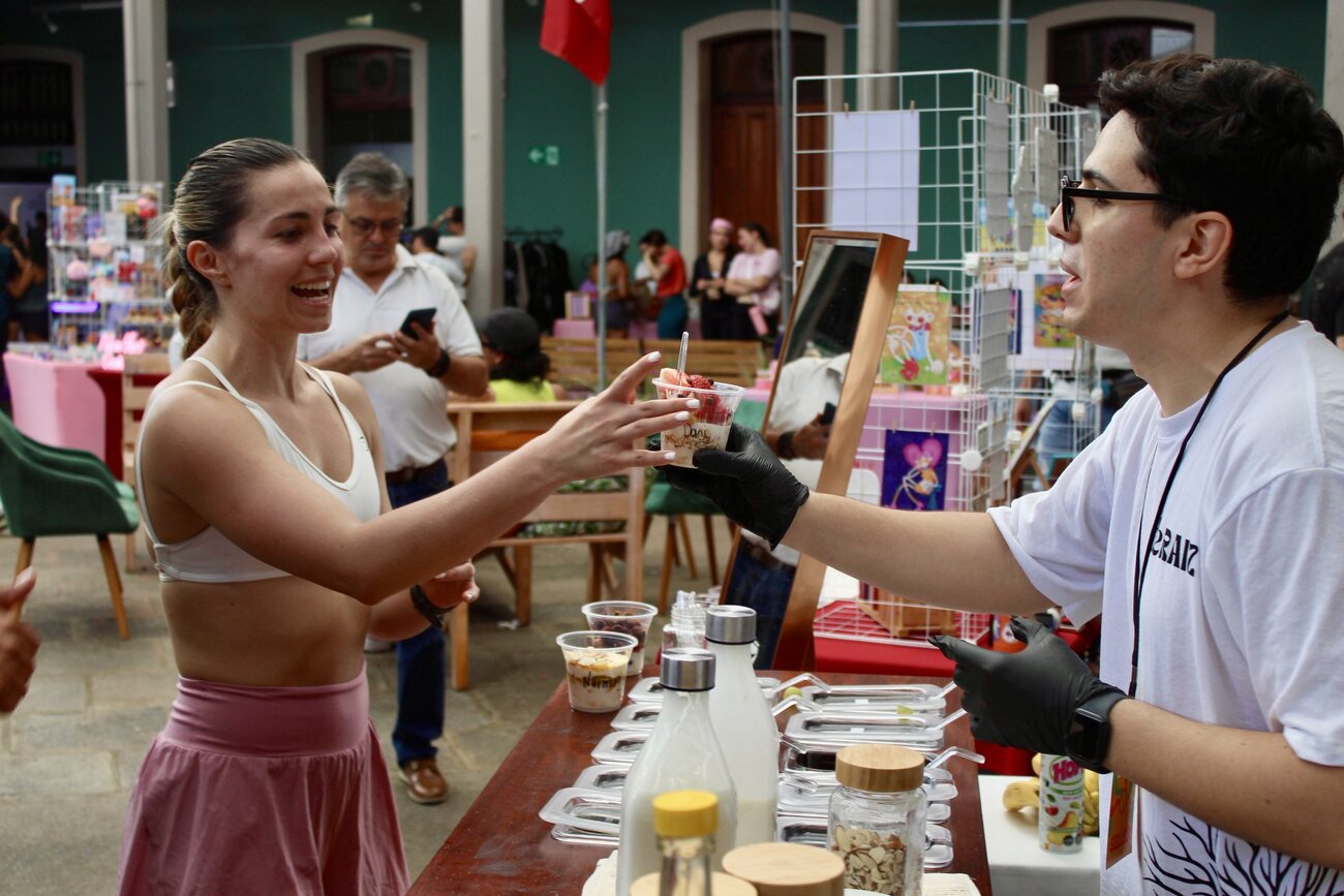 Clienta recibiendo su parfait en el stand deRAÍZ